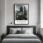 A curated art gallery wall featuring a framed Bangkok poster as the centerpiece among other prints.