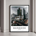 A framed poster of Bangkok, Thailand's cityscape with a black frame, styled in a modern interior setting.