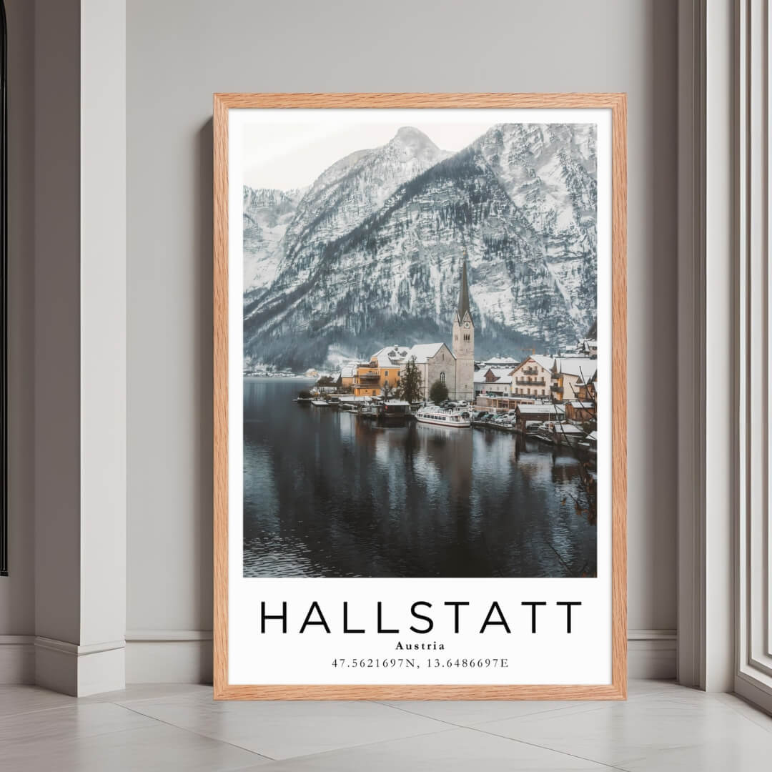 A framed print of Hallstatt, Austria, with a rustic red oak wood frame, highlighting the charming village and snowy mountains.