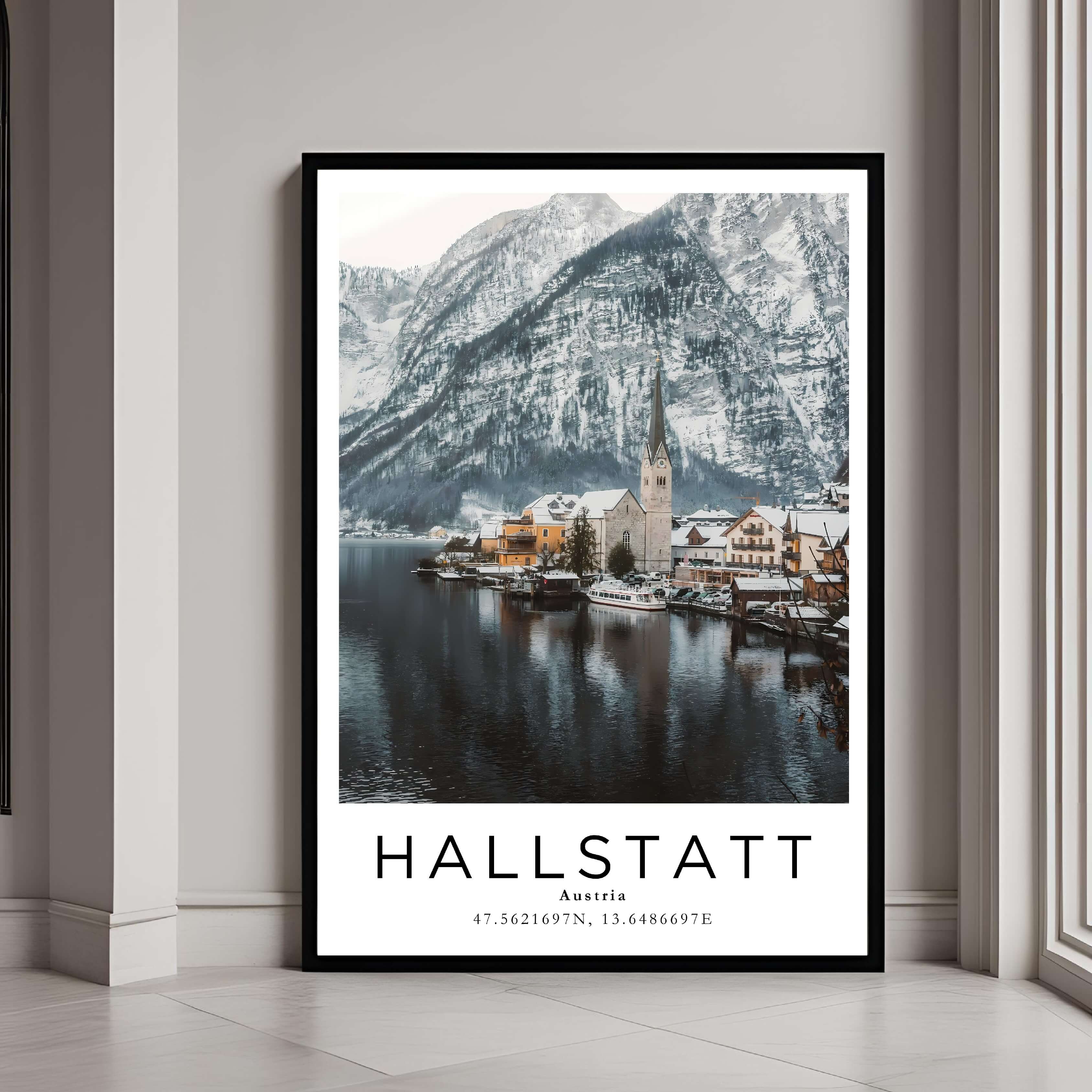A framed poster of Hallstatt, Austria, in winter with a classic black frame, styled in a modern interior.