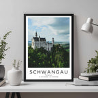 A framed travel poster of Schwangau displayed on a wall in a home office, adding an element of professional and artistic flair.
