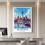 A framed travel poster of Auckland displayed on a wall in a home office, adding an element of professional and artistic flair.