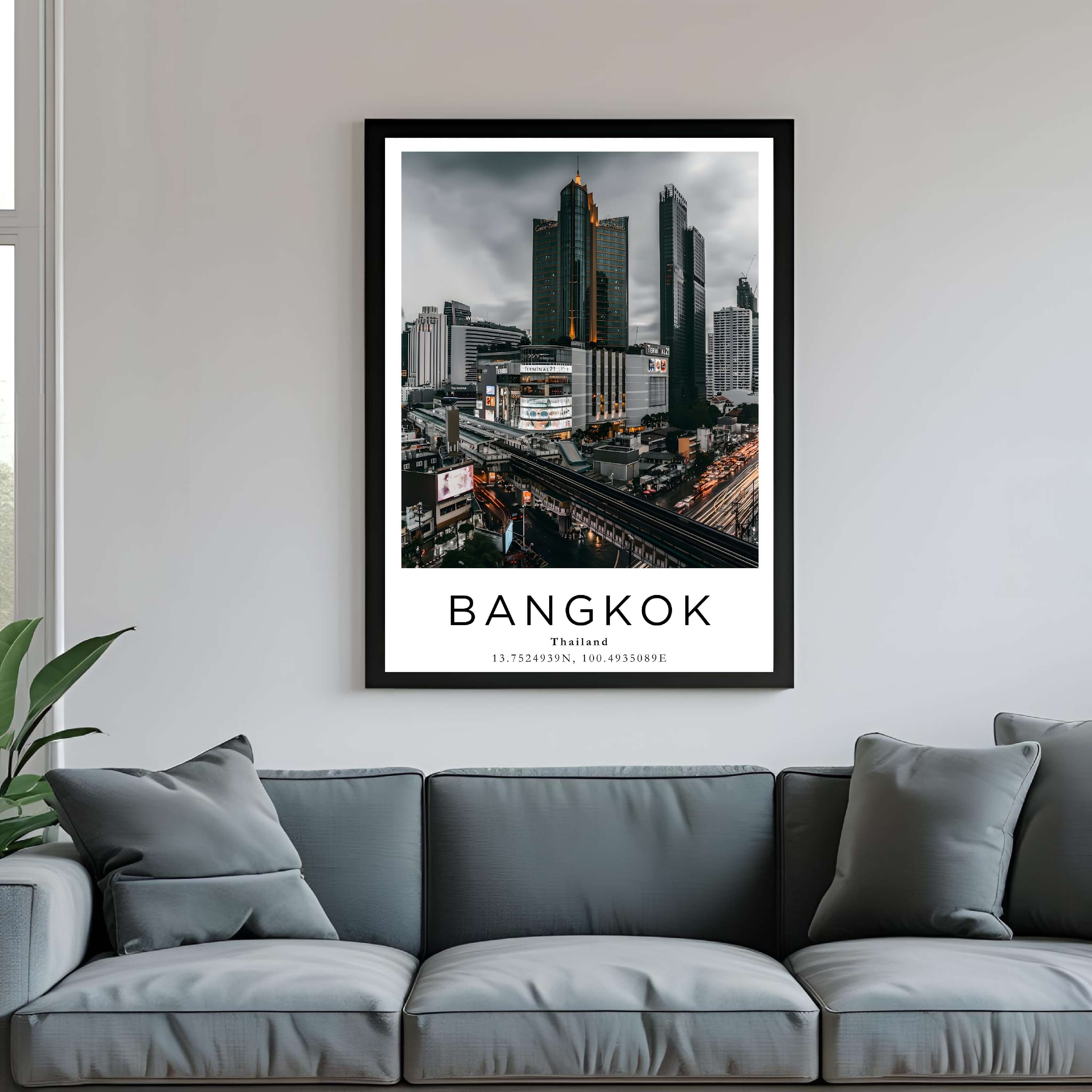 A framed art print of Bangkok's skyline hanging above a couch, enhancing the style of a modern living room.