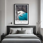 A framed art print of the Greek beach decorating a bedroom wall, creating a peaceful and luxurious atmosphere.