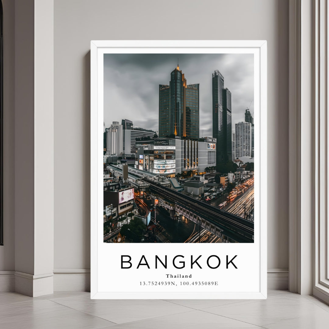 A framed art print of Bangkok's cityscape decorating a bedroom wall with a clean and contemporary design.