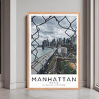 A framed print of Manhattan, New York, with a rustic red oak wood frame, highlighting the urban architecture.
