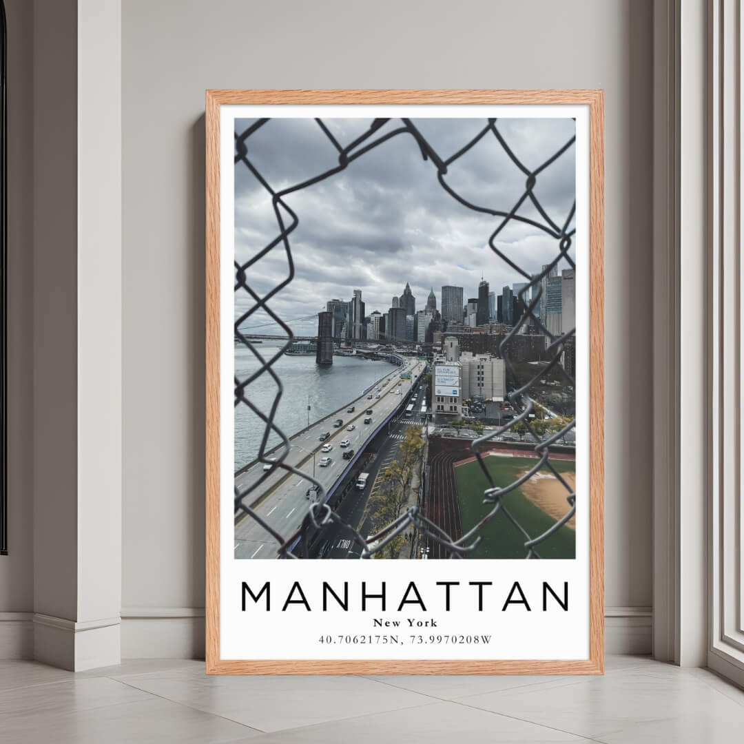 A framed print of Manhattan, New York, with a rustic red oak wood frame, highlighting the urban architecture.