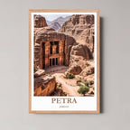 A framed photograph of the Petra Treasury from above the Siq, highlighting the sandstone cliffs and the crowd below, in a natural wood/oak frame.